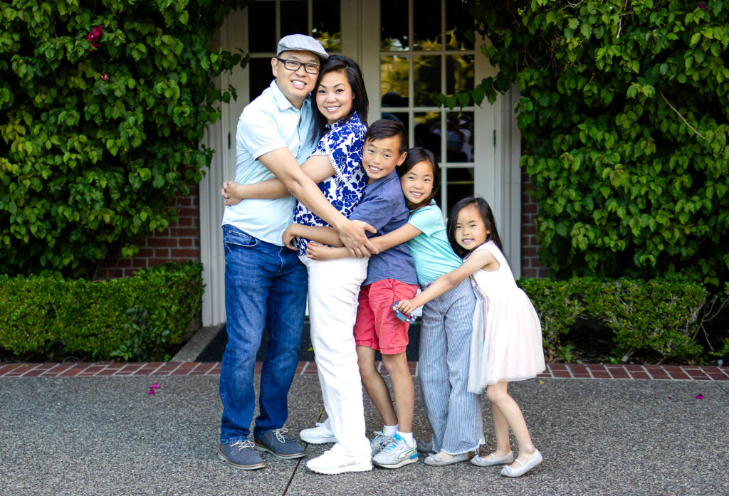 Family group hug in front of ivy-covered doorway at Kohl Mansion Burlingame