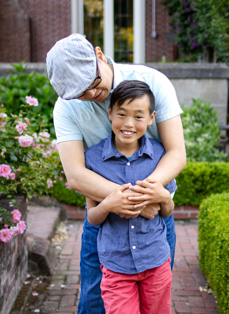 Sweet father-son hug during golden hour in the rose garden at Kohl Mansion Burlingame