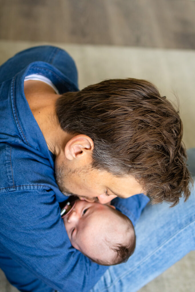 Loving kiss from dad during a Newborn Lifestyle Photography session in San Francisco.