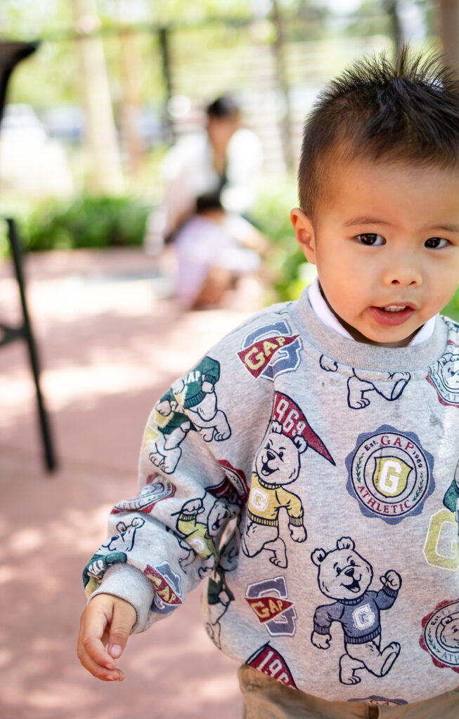 Joyful toddler exploring outdoors during a relaxed lifestyle family photoshoot.