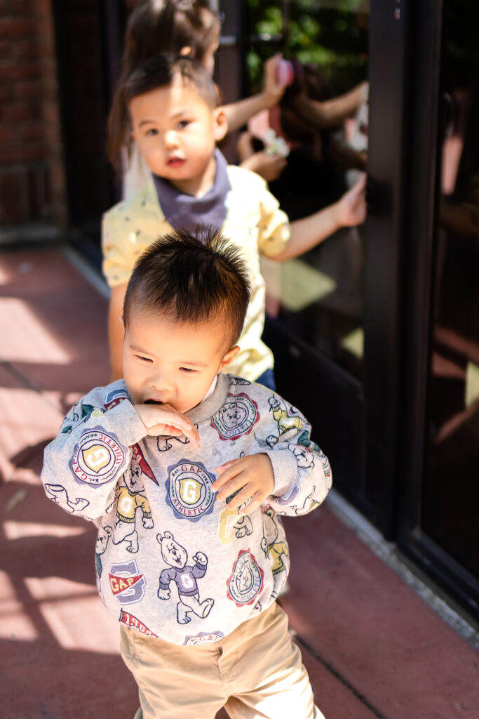 Joyful toddler exploring outdoors during a relaxed lifestyle family photoshoot.