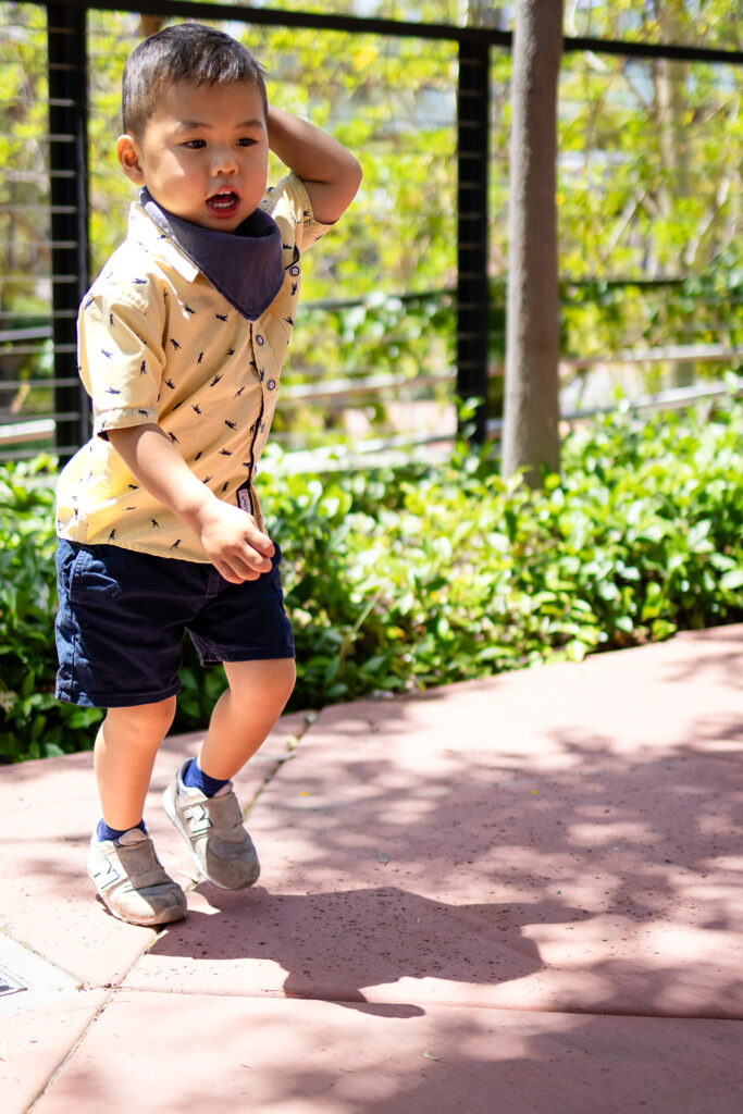 Little boy in yellow shirt running with energy and joy during a candid lifestyle family photography session