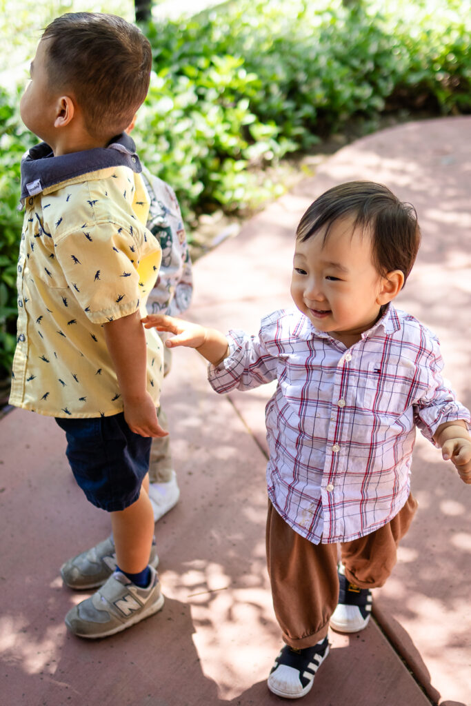 Joyful toddler exploring outdoors during a relaxed lifestyle family photoshoot.
