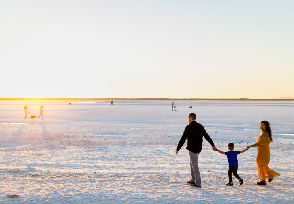Family holding hands and walking into the sunset on the salt flats at Alviso Marina County Park – Ellobelle Photography
