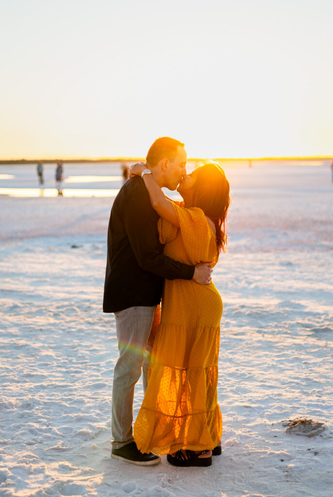 Couple kisses at sunset on the glowing white salt flats of Alviso Marina County Park – Ellobelle Photography