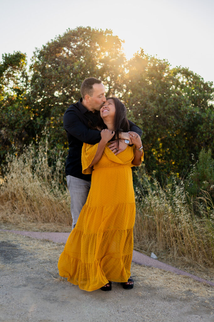 Couple shares a sweet golden hour kiss surrounded by tall grass at Alviso Marina County Park – Ellobelle Photography