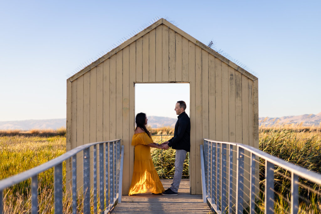 Couple holding hands inside the iconic framed structure at Alviso Marina County Park – Ellobelle Photography
