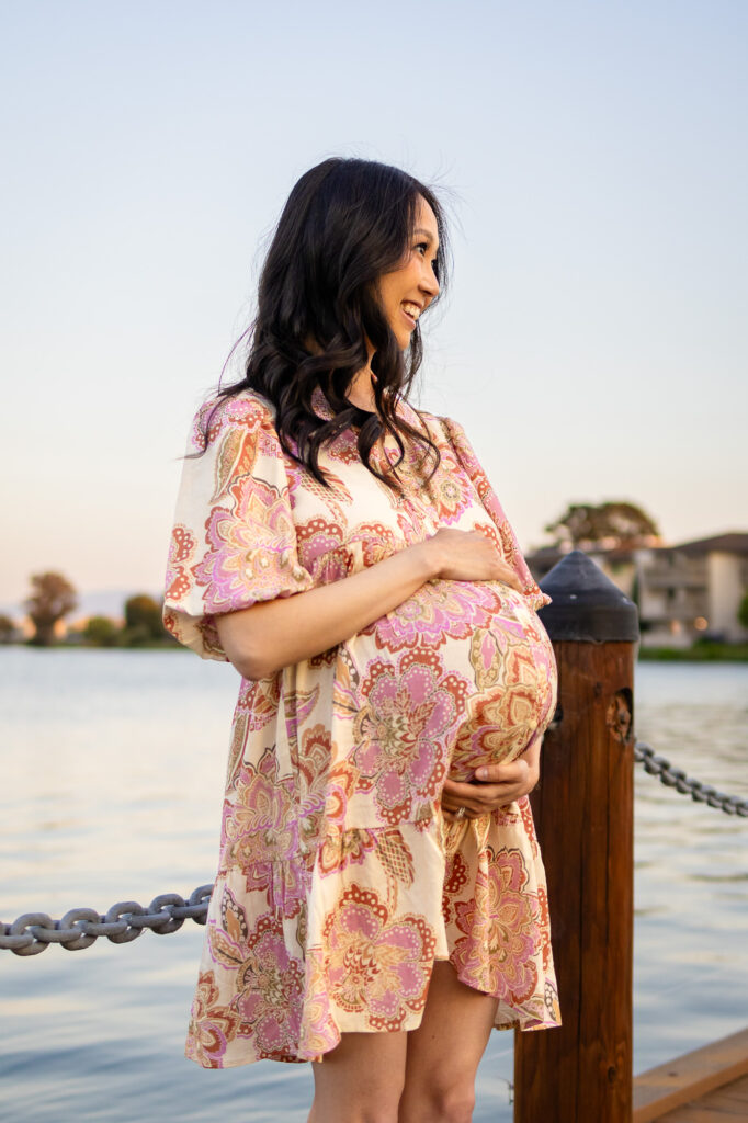 Maternity Photography Poses – ellobelle photography: Couple sits closely on dock with mom-to-be resting her head on partner