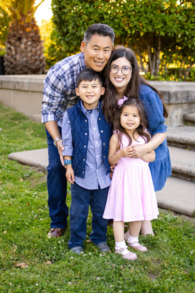 Full family smiling at camera in coordinated blues and pink – What to Wear for Family Photoshoot