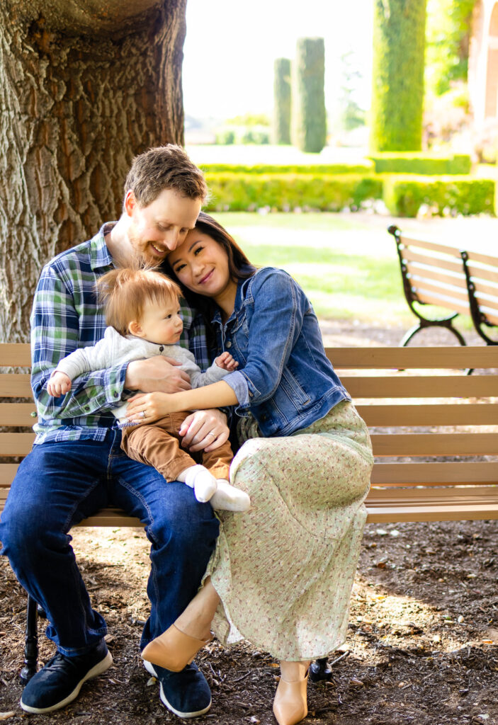 What to Wear for Family Photoshoot a peaceful family cuddle on a park bench under the trees.