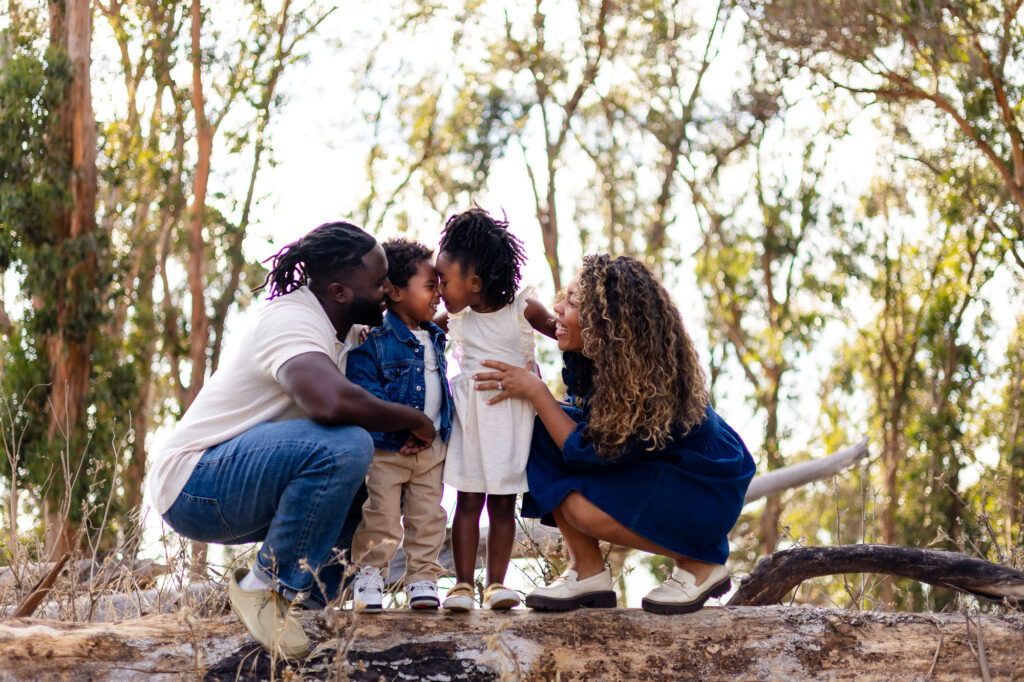 Family laughing together on a log – Ellobelle Photography