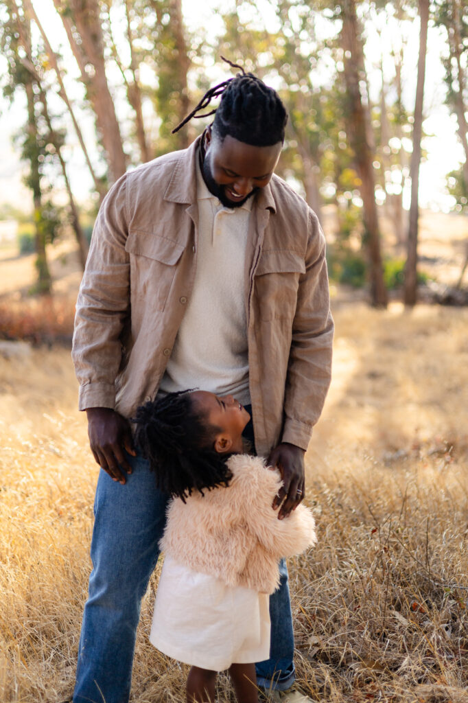 Father and daughter smiling together in golden field at Coyote Point – Ellobelle Photography
