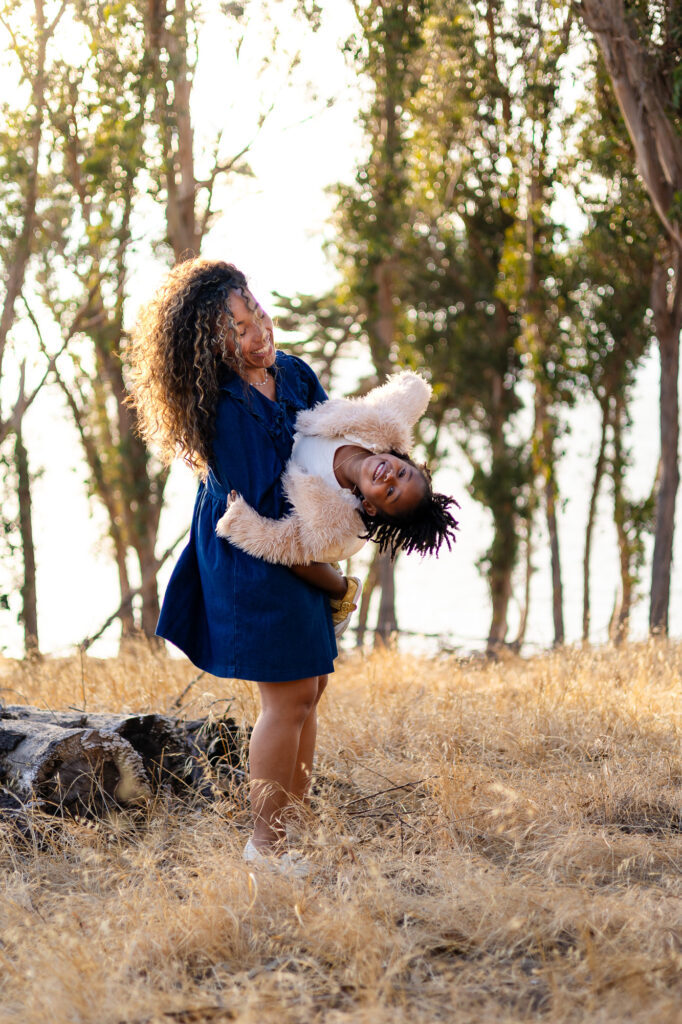 Mother holding daughter upside down while laughing at Coyote Point – Ellobelle Photography