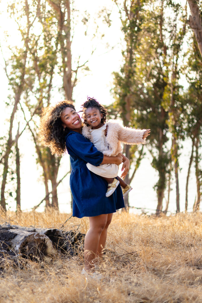 Mother holding daughter and smiling at Coyote Point – Ellobelle Photography