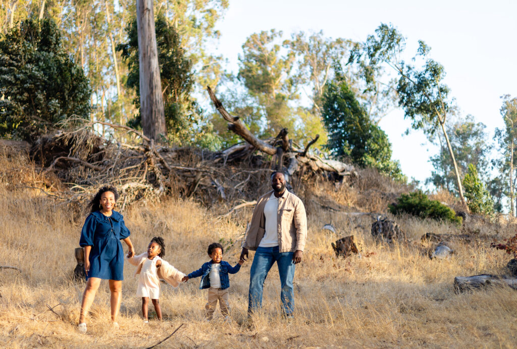 Family standing hand in hand in wide field at Coyote Point – Ellobelle Photography