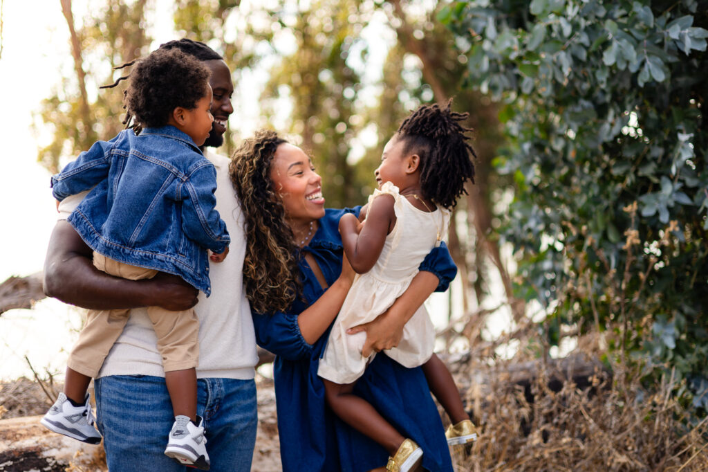 Family laughing while holding children – Ellobelle Photography
