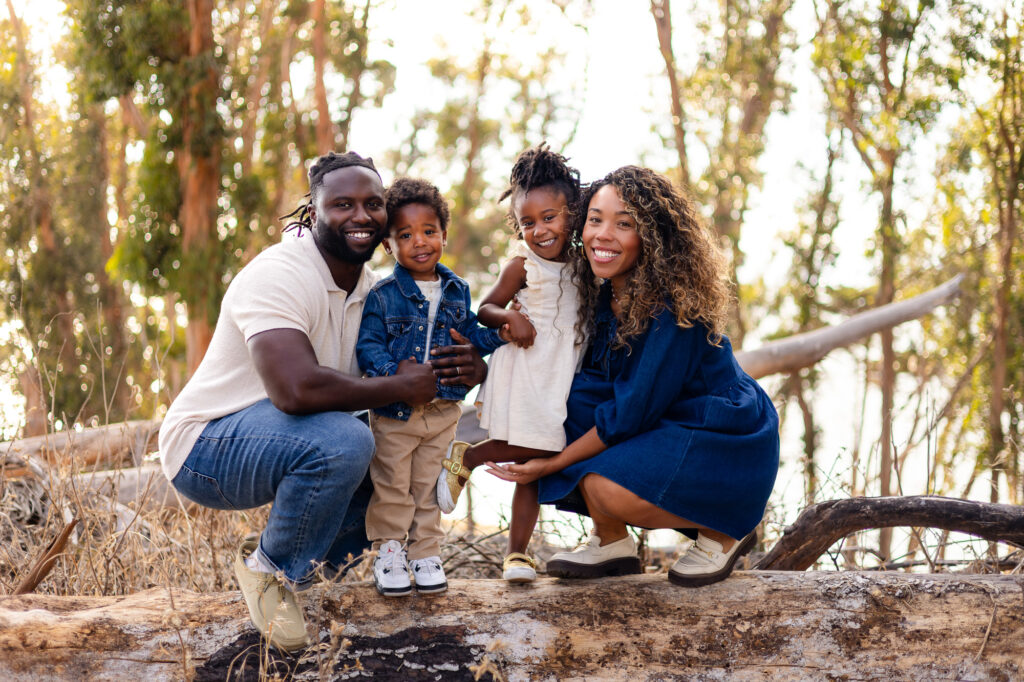 Smiling family portrait with kids on a log at Coyote Point – Ellobelle Photography