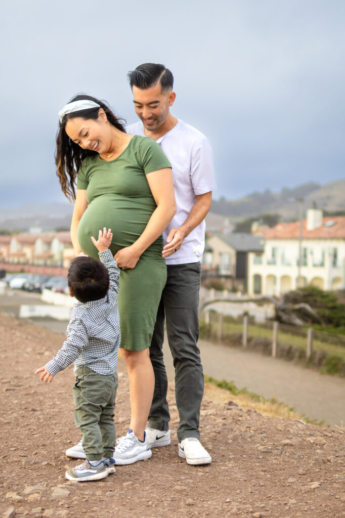Family cuddles during golden hour with waves in the background — a beautiful reminder of the best time for maternity photos.