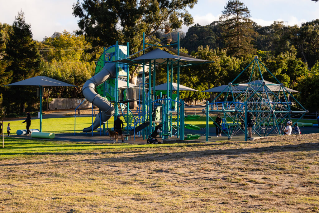 Wide shot of kids playing on colorful structures at Millbrae Central Park – Ellobelle Photography