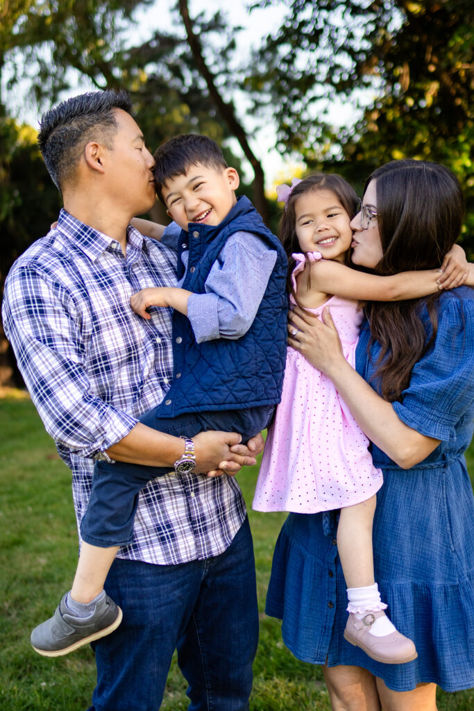 Dad kisses son while mom kisses daughter during family photos at Kolh Mansion Burlingame – Ellobelle Photography