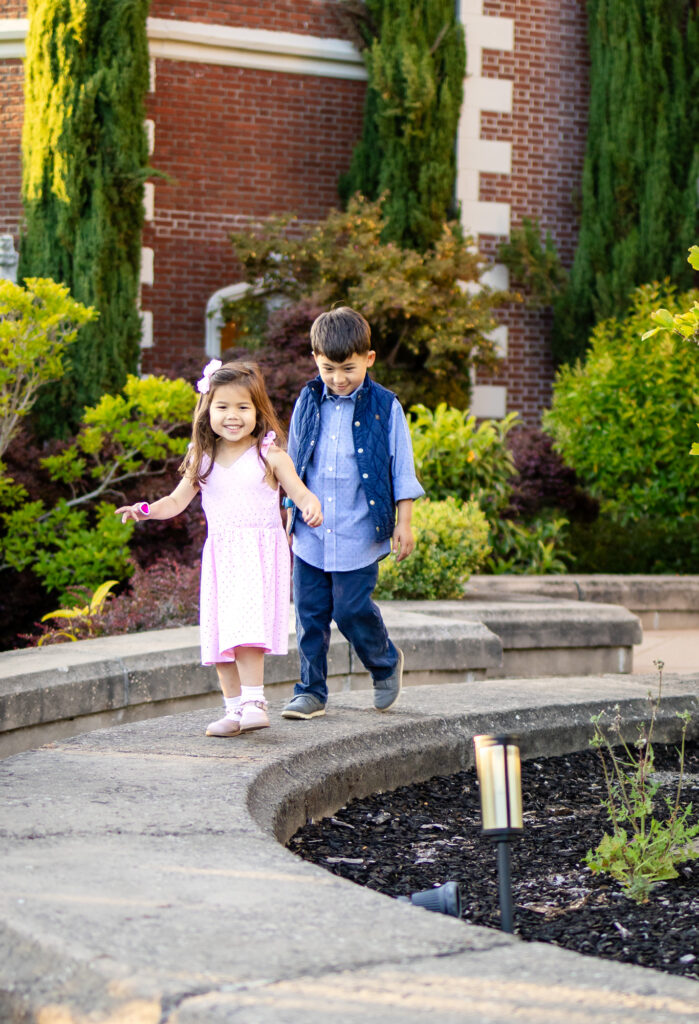 Kids walking hand in hand near red brick walls at Kolh Mansion Burlingame – Ellobelle Photography