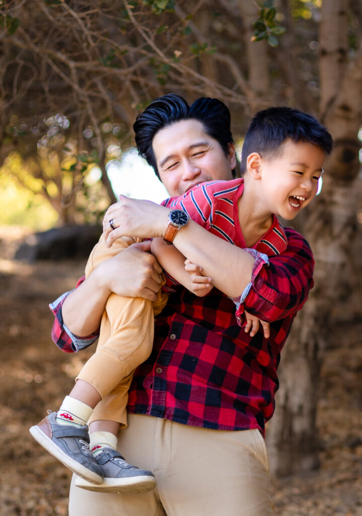 Dad holding child with joyful smiles during a San Francisco Peninsula outdoor location family session