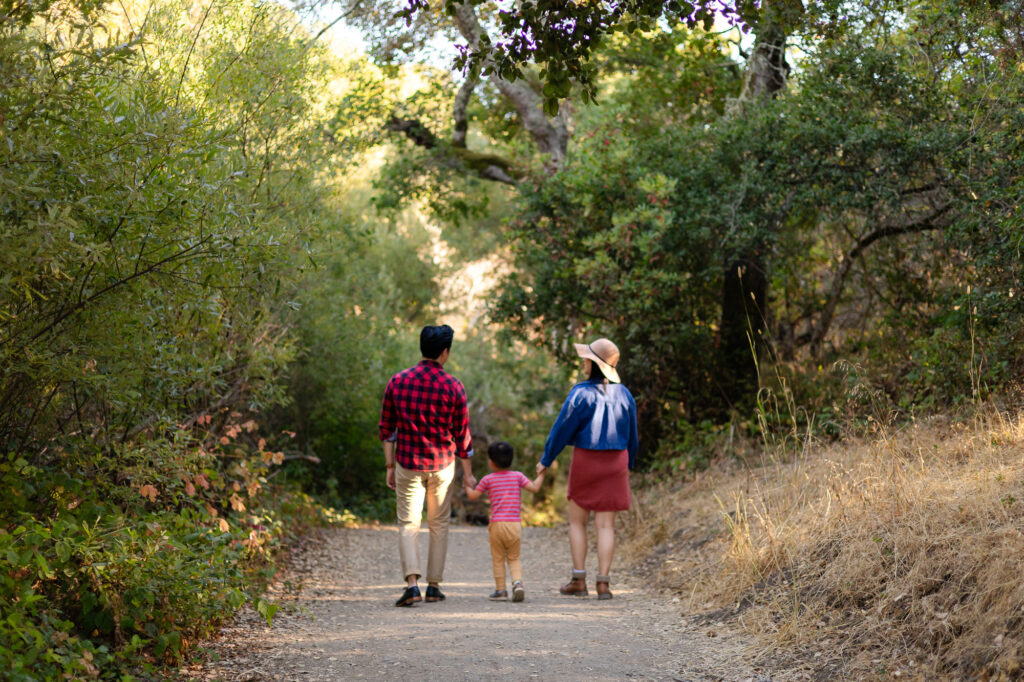 Family walking hand in hand along shaded trail at Laurelwood Park – Ellobelle Photography