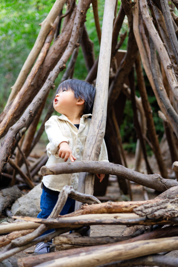 Toddler exploring wooden teepee structure at Redwood Grove Nature Preserve photos – Ellobelle Photography
