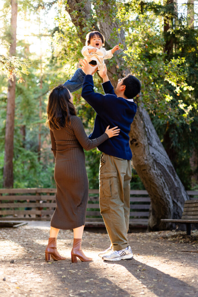 Playful family moment at Redwood Grove Nature Preserve with dad lifting child in the air – Ellobelle Photography