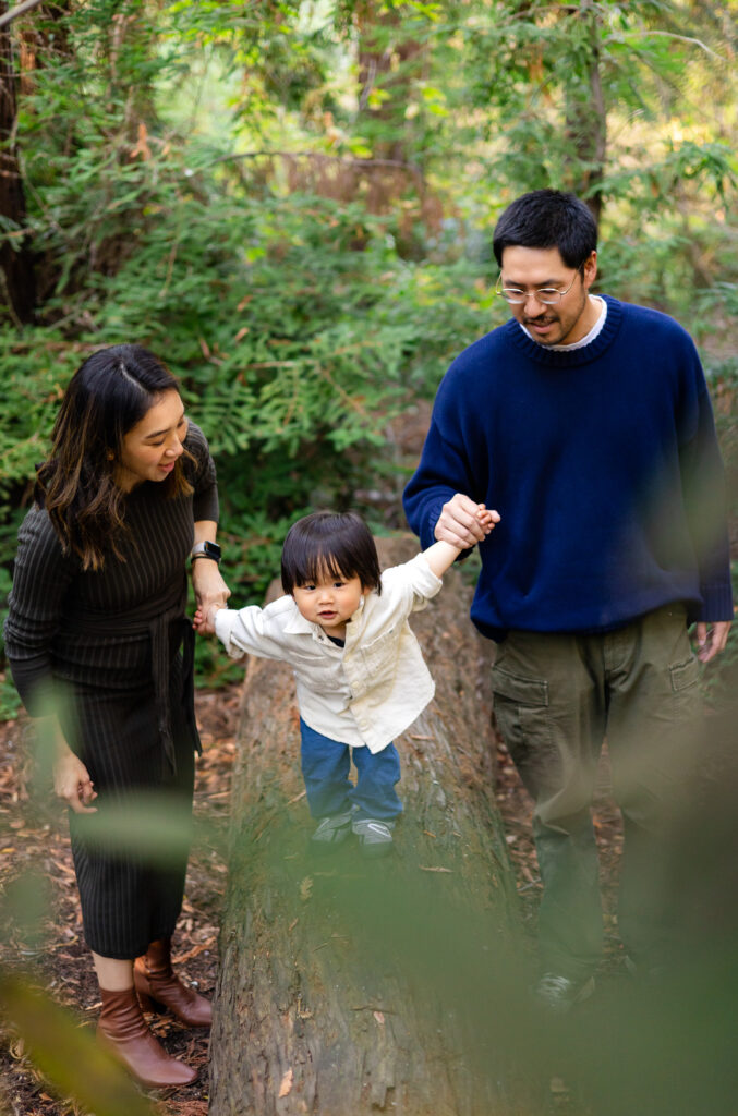 Child balancing on a log with parents’ support at Redwood Grove Nature Preserve – Ellobelle Photography