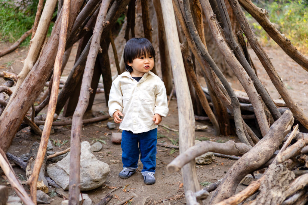 Toddler exploring wooden stick teepee at Redwood Grove Los Altos – Ellobelle Photography
