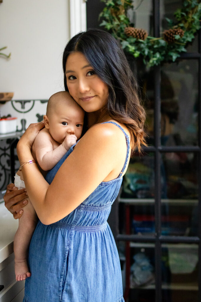 Mom gently holding newborn in cozy kitchen – San Francisco Newborn Photography by Ellobelle Photography