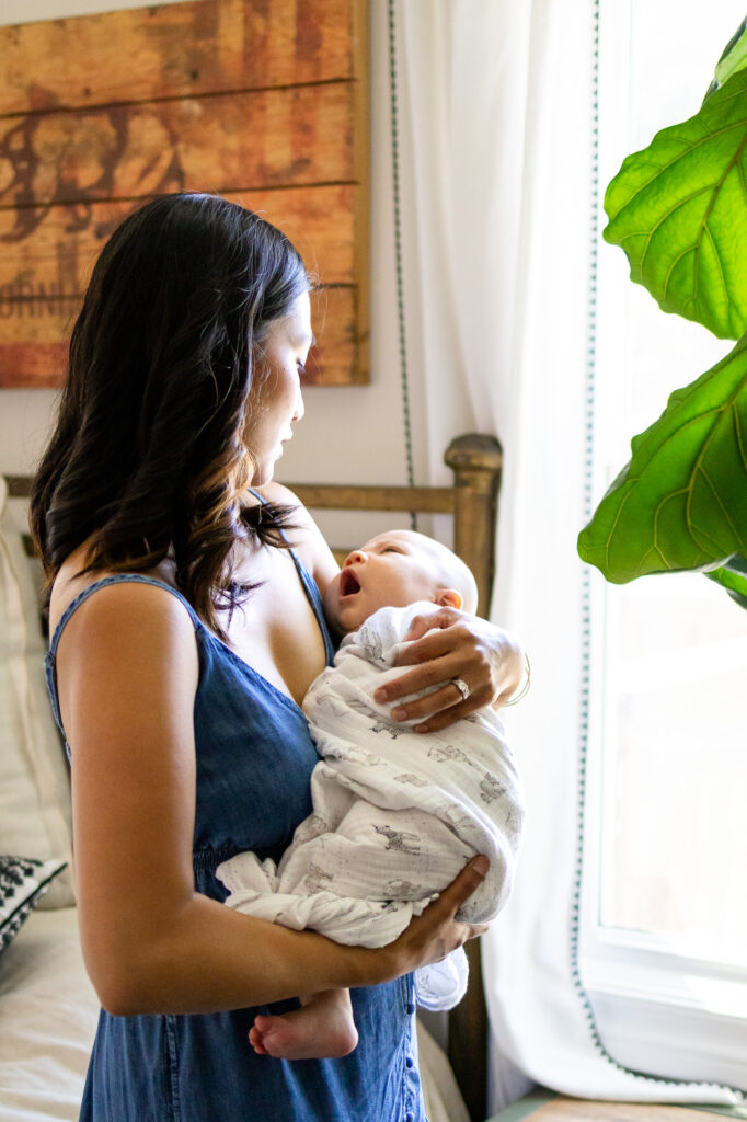 Mother comforting yawning baby by bedroom window – San Francisco Newborn Photography by Ellobelle Photography