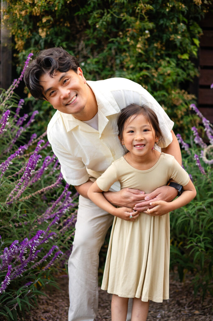 Dad and daughter smiling together among purple flowers at Washington Park Burlingame – Ellobelle Photography
