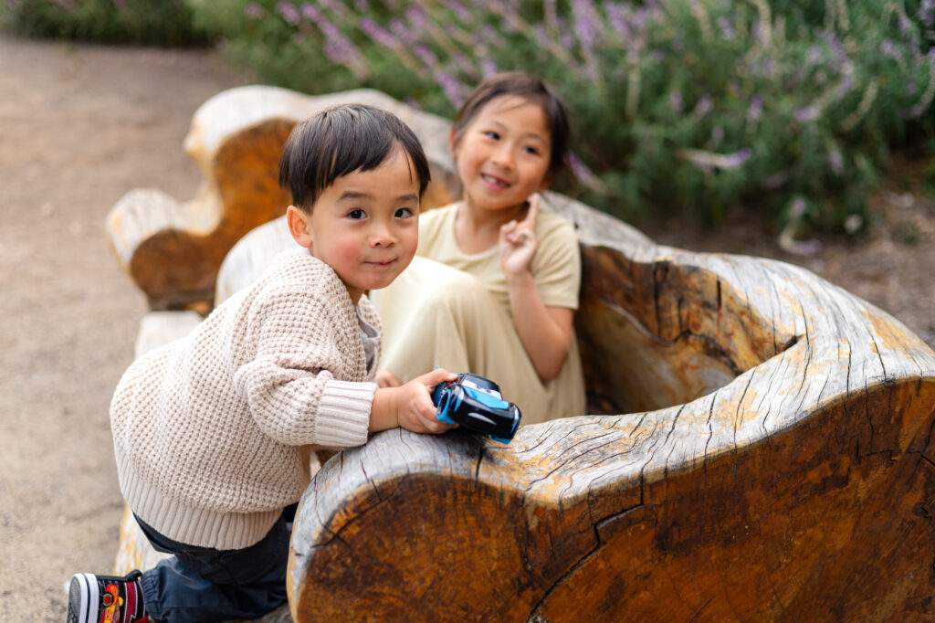 Brother and sister playing together on wooden bench at Washington Park Burlingame – Ellobelle Photography