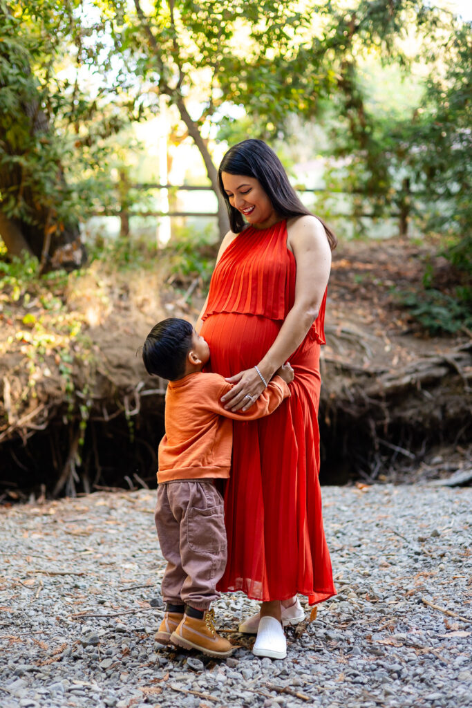 Young boy hugging his pregnant mom outdoors during Bay Area maternity shoot – Ellobelle Photography