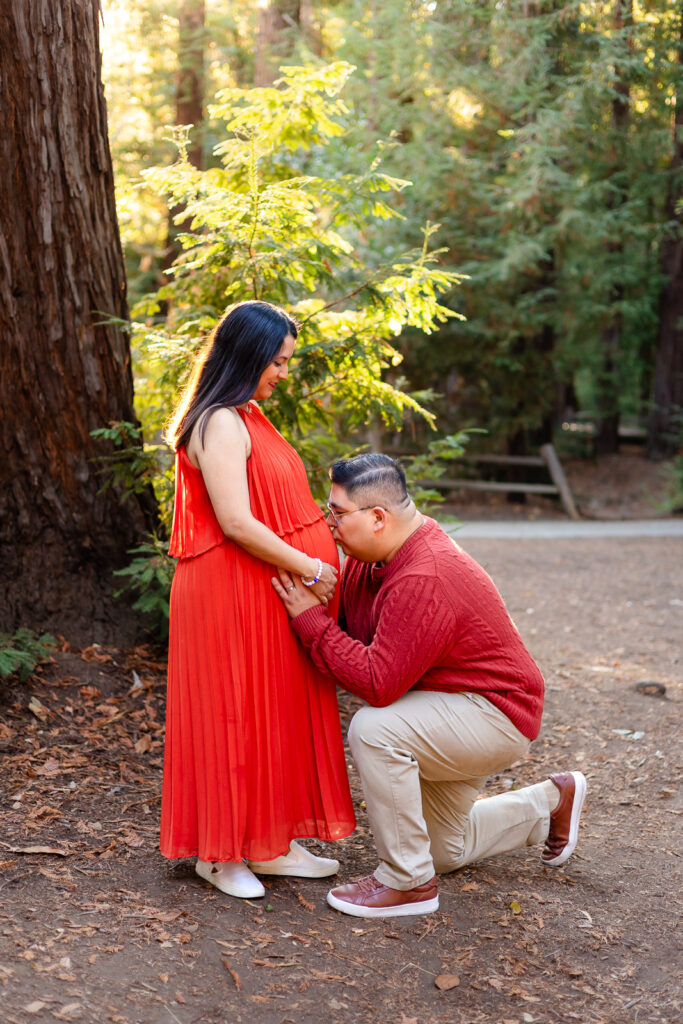 Dad kneeling to kiss baby bump during outdoor Bay Area maternity shoot – Ellobelle Photography
