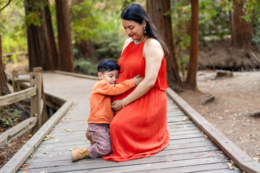 Child hugging mom’s pregnant belly during heartfelt Bay Area maternity session – Ellobelle Photography