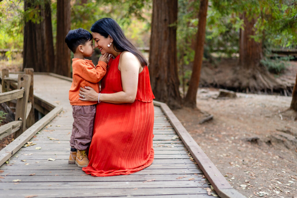 Son and pregnant mom touching foreheads in a Bay Area redwood setting – Ellobelle Photography