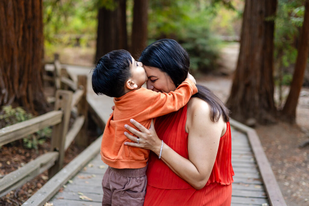 Little boy hugging mom and giving forehead kiss during maternity session – Ellobelle Photography