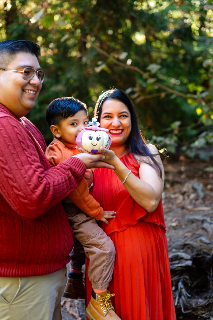 Family holding painted baby pumpkin during Bay Area maternity announcement – Ellobelle Photography