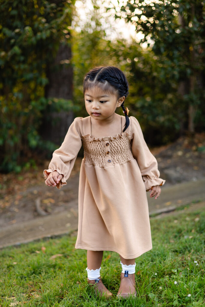 Toddler exploring grassy park during holiday photo sessions – Ellobelle Photography