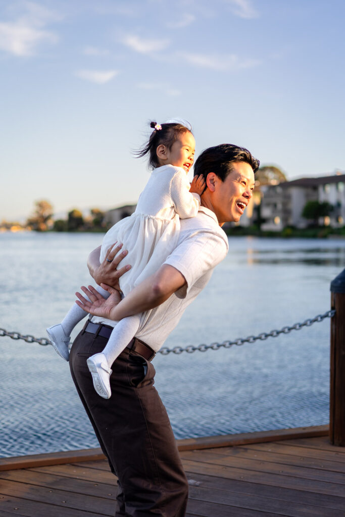 Happy moment between dad and daughter on a dock at Leo Ryan Park