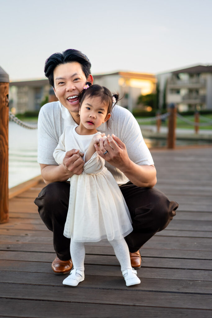 Dad kneeling with daughter on dock at Foster City community park