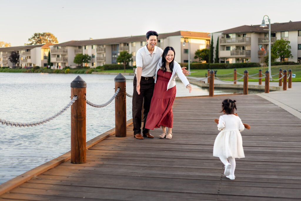Parents cheering as daughter runs toward them at waterfront paths at Leo Ryan Park