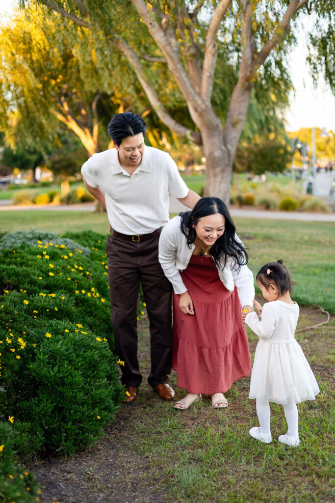 Parents watching daughter explore flowers at Peninsula waterfront location