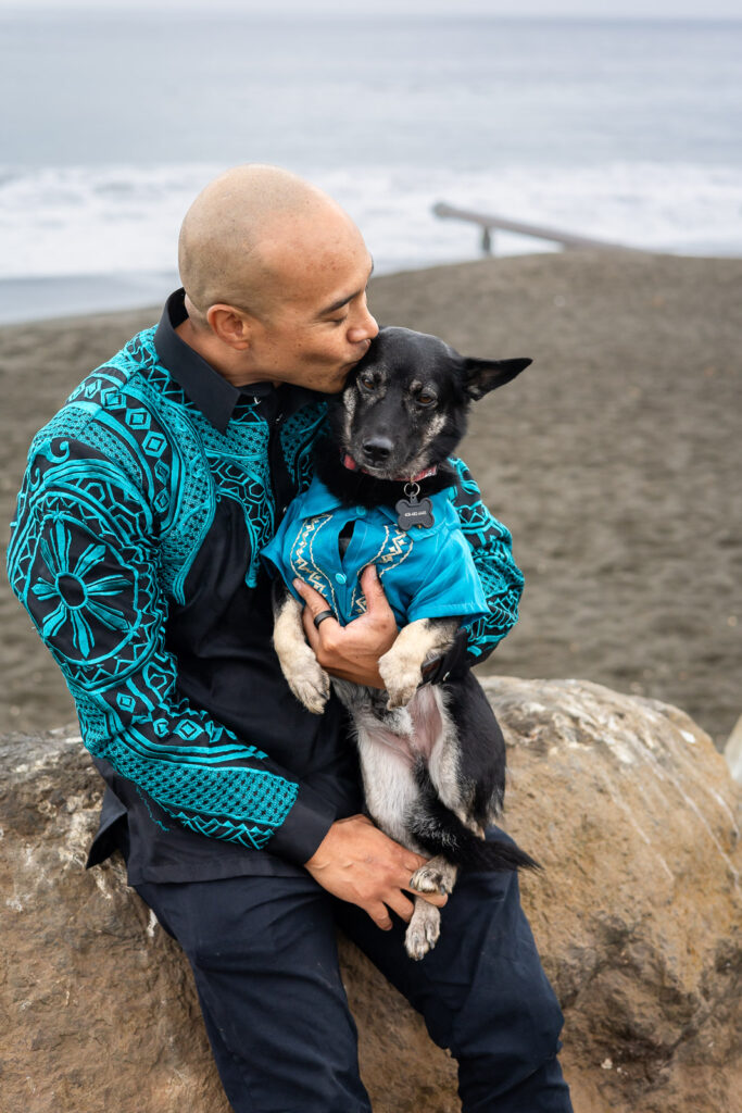 Man kissing his dog’s head during a sweet moment in their dog inclusive family session