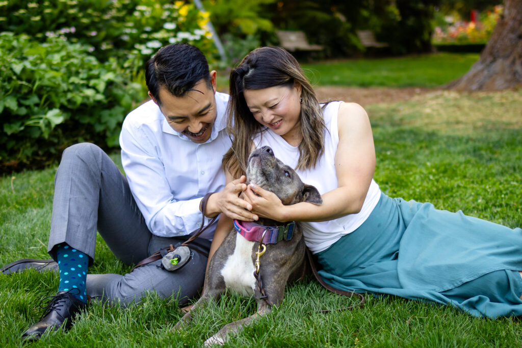 Couple playing with their dog on the grass during a fun and relaxed photoshoot with your dog