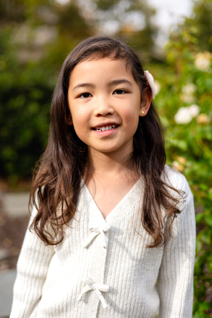 Young girl outdoors surrounded by greenery during school photos with Bay Area Preschool Photographer in Burlingame – Ellobelle Photography