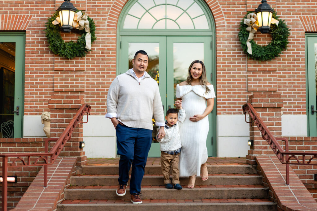 Family walking down Filoli steps decorated with wreaths during Filoli Christmas portraits